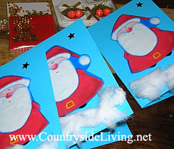 Самодельные детские открытки моей дочери. Цветная плотная бумага, вырезанные изображения Деда Мороза из новогодней упаковочной бумаги, вата ('снег') и звездочки