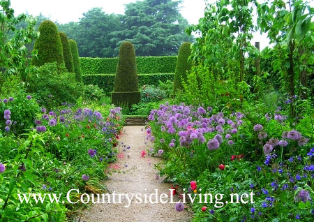 Топиарии по соседству с неформальными посадками, сад Хиткот, г-во Глостершир, Англия